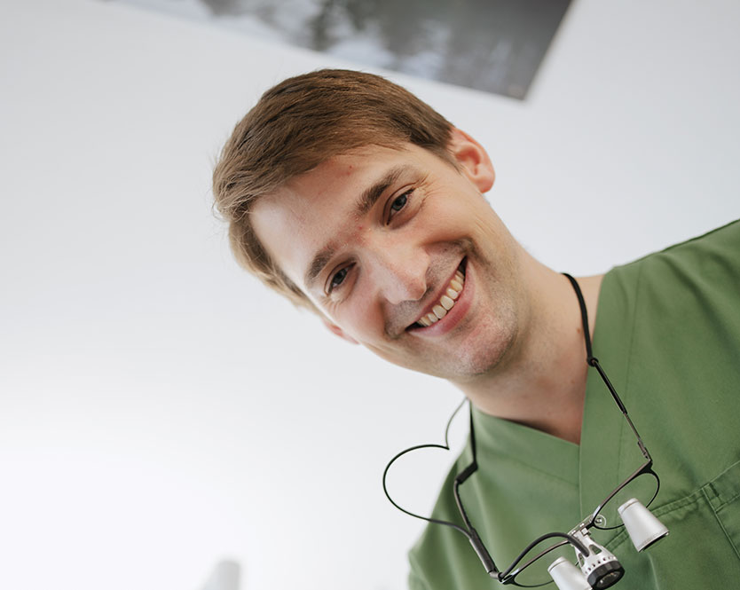 Dr Schipp blickt von oben auf die Kamera und lächelt