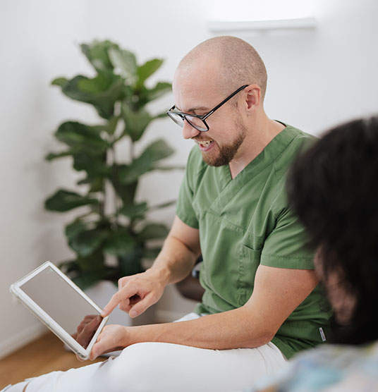 Dr Neubert berät eine Patientin am Tablet